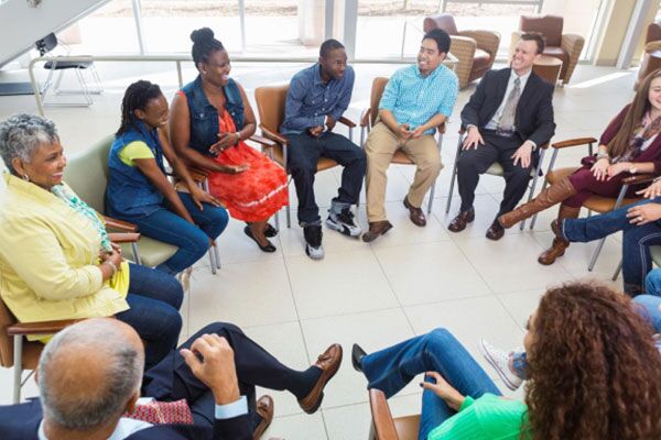 A group of eleven adults sitting in a circle.
